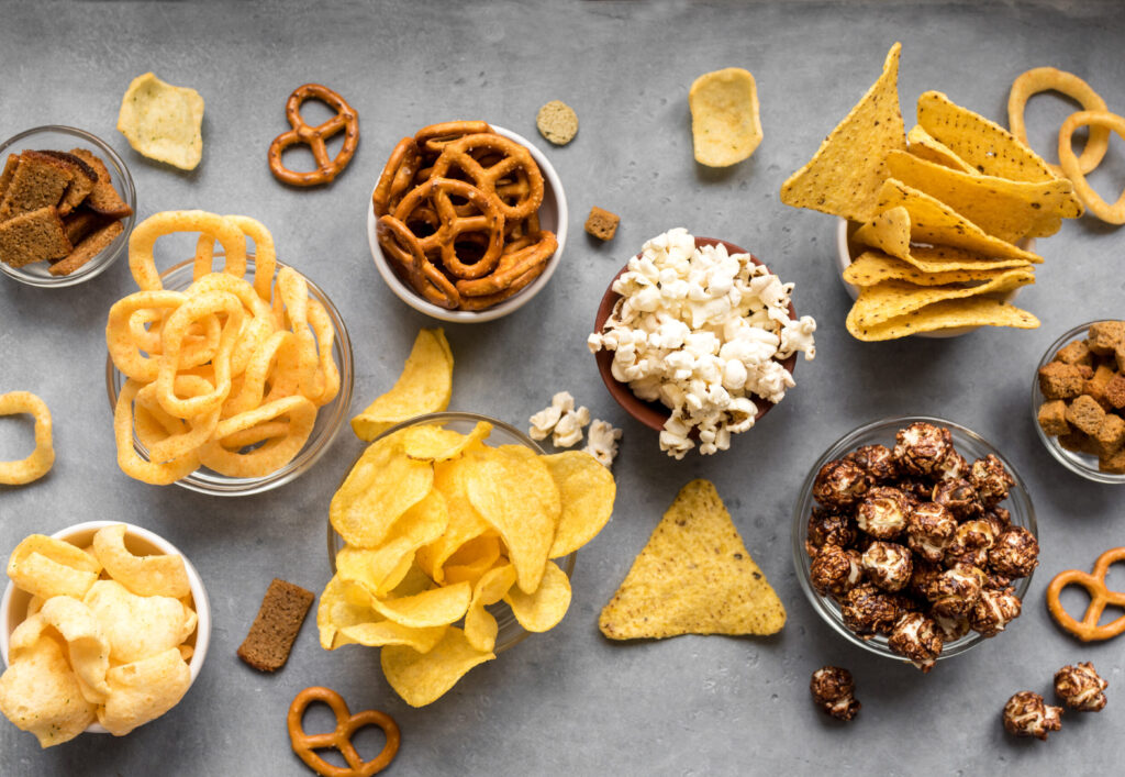 Assortment,Of,Unhealthy,Snacks:,Chips,,Popcorn,,Nachos,,Pretzels,,Onion,Rings